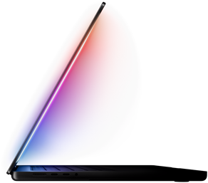 A slightly open MacBook Pro casts a multicolored glow from the screen onto the keyboard